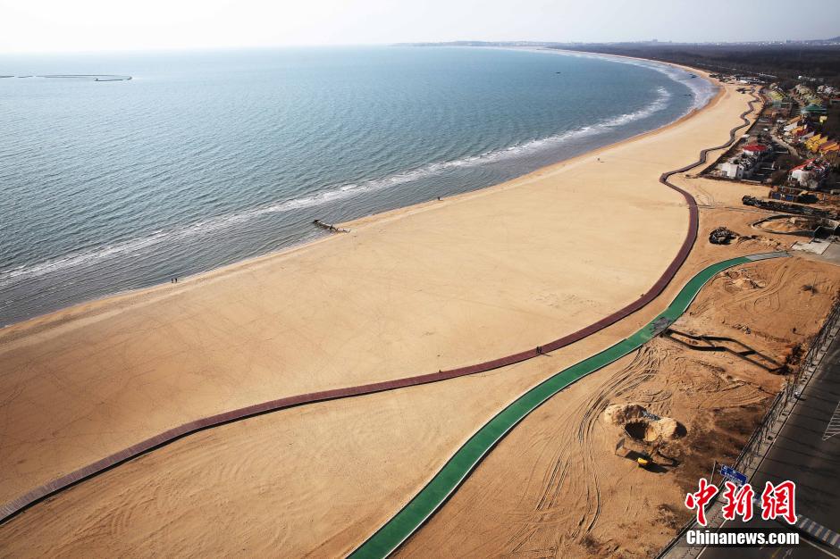 3月13日，秦皇島萬(wàn)米臨海沙灘木棧道。據(jù)了解，該木棧道全長(zhǎng)約4200米，與北戴河區(qū)原有的7500米木棧道對(duì)接后全線總長(zhǎng)度1.17萬(wàn)米，整個(gè)木棧道東起秦皇島體育基地游船碼頭，西至北戴河濕地公園，呈波浪形蜿蜒10.4公里海岸線。 中新社發(fā) 曹建雄 攝 CNSPHOTO