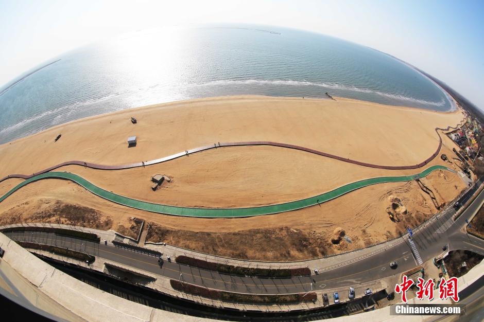 3月13日，秦皇島萬(wàn)米臨海沙灘木棧道。據(jù)了解，該木棧道全長(zhǎng)約4200米，與北戴河區(qū)原有的7500米木棧道對(duì)接后全線總長(zhǎng)度1.17萬(wàn)米，整個(gè)木棧道東起秦皇島體育基地游船碼頭，西至北戴河濕地公園，呈波浪形蜿蜒10.4公里海岸線。 中新社發(fā) 曹建雄 攝 CNSPHOTO